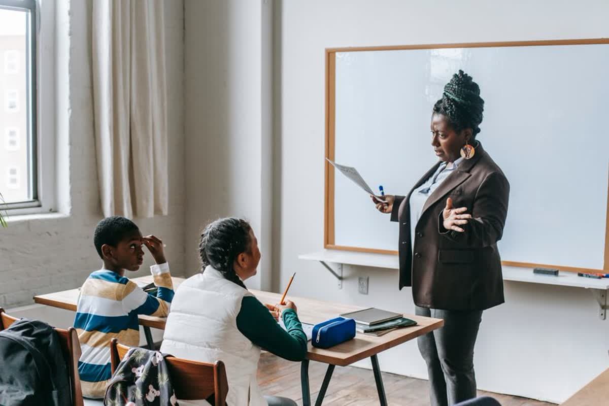 A teacher explaining a lesson to elementary school pupils in a classroom